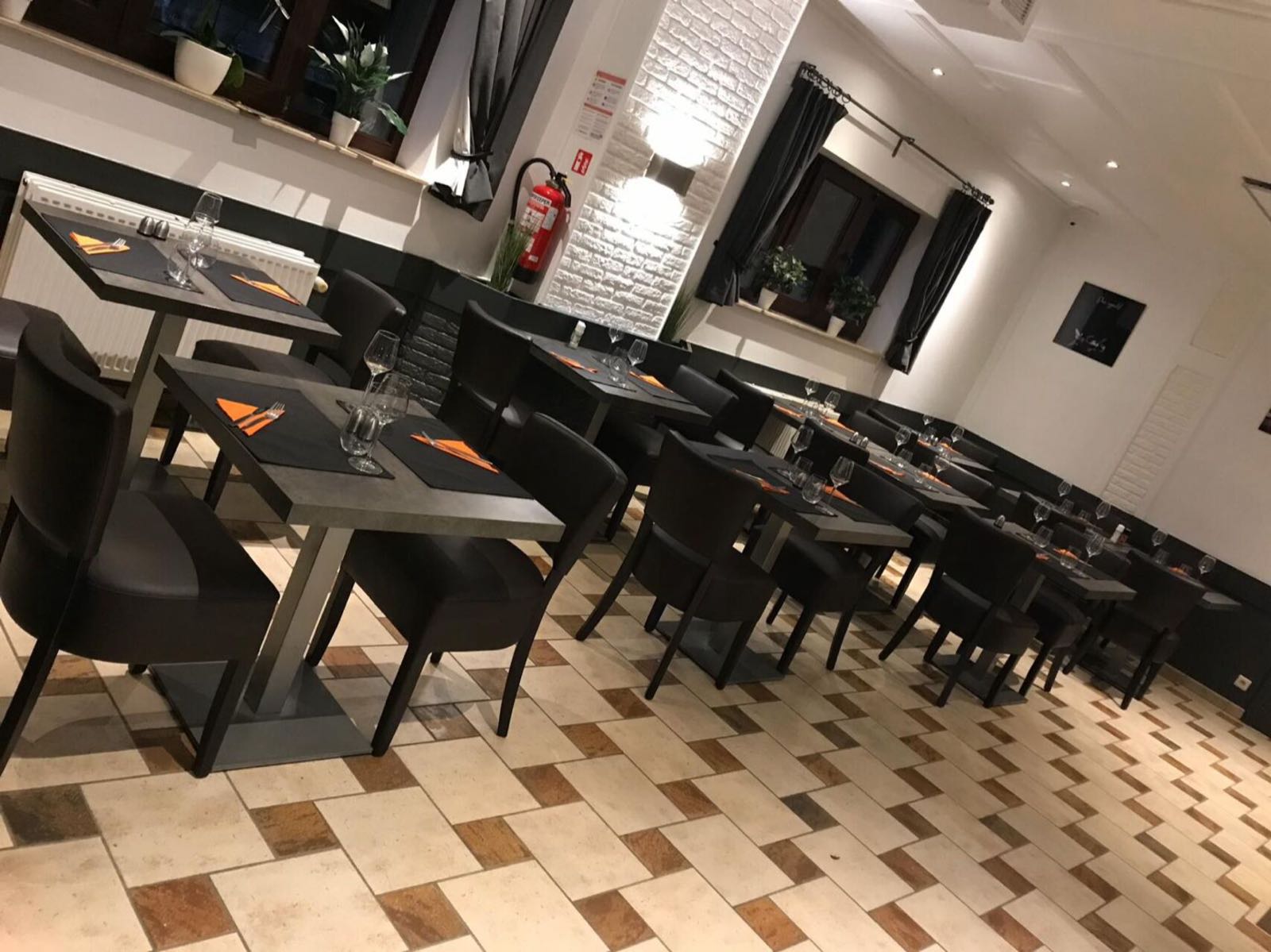 La salle de la Brasserie du Vieux Chastre, ses tables dressées et ses murs en briques blanches